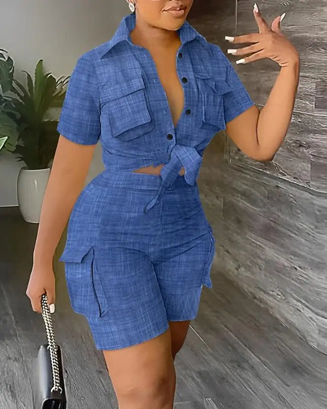 Woman wearing a blue two-piece summer outfit with a short-sleeve tied shirt and high-waisted cargo shorts