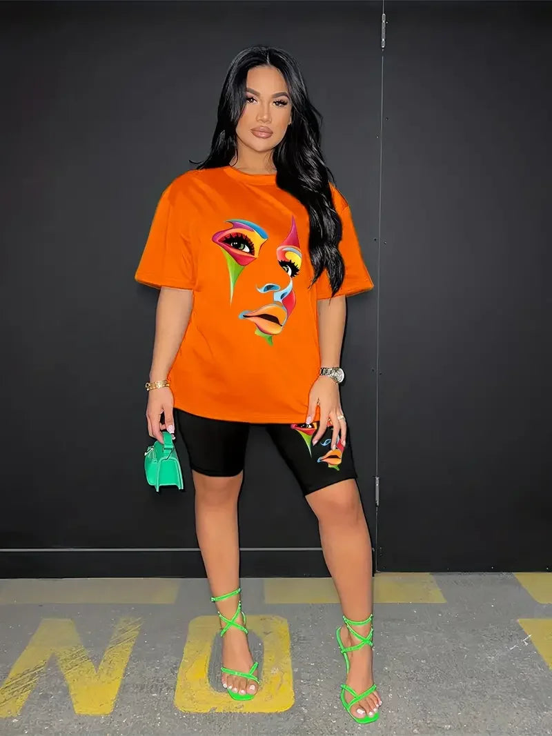 Woman wearing a chic two-piece set with an orange graphic t-shirt and black skinny shorts with matching face print