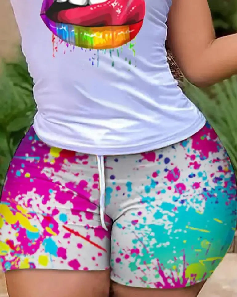 Close-up of colorful tie-dye splattered shorts paired with a white graphic t-shirt featuring rainbow lips design