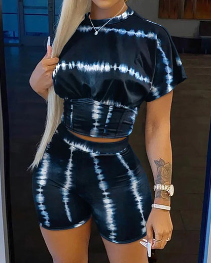 Woman wearing a black and white tie-dye two-piece summer outfit with a crop top and fitted shorts