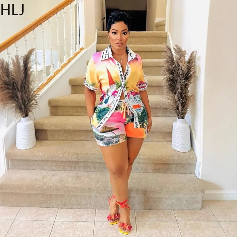 Woman wearing a colorful two-piece summer outfit with a short-sleeve button-up top and matching shorts standing indoors