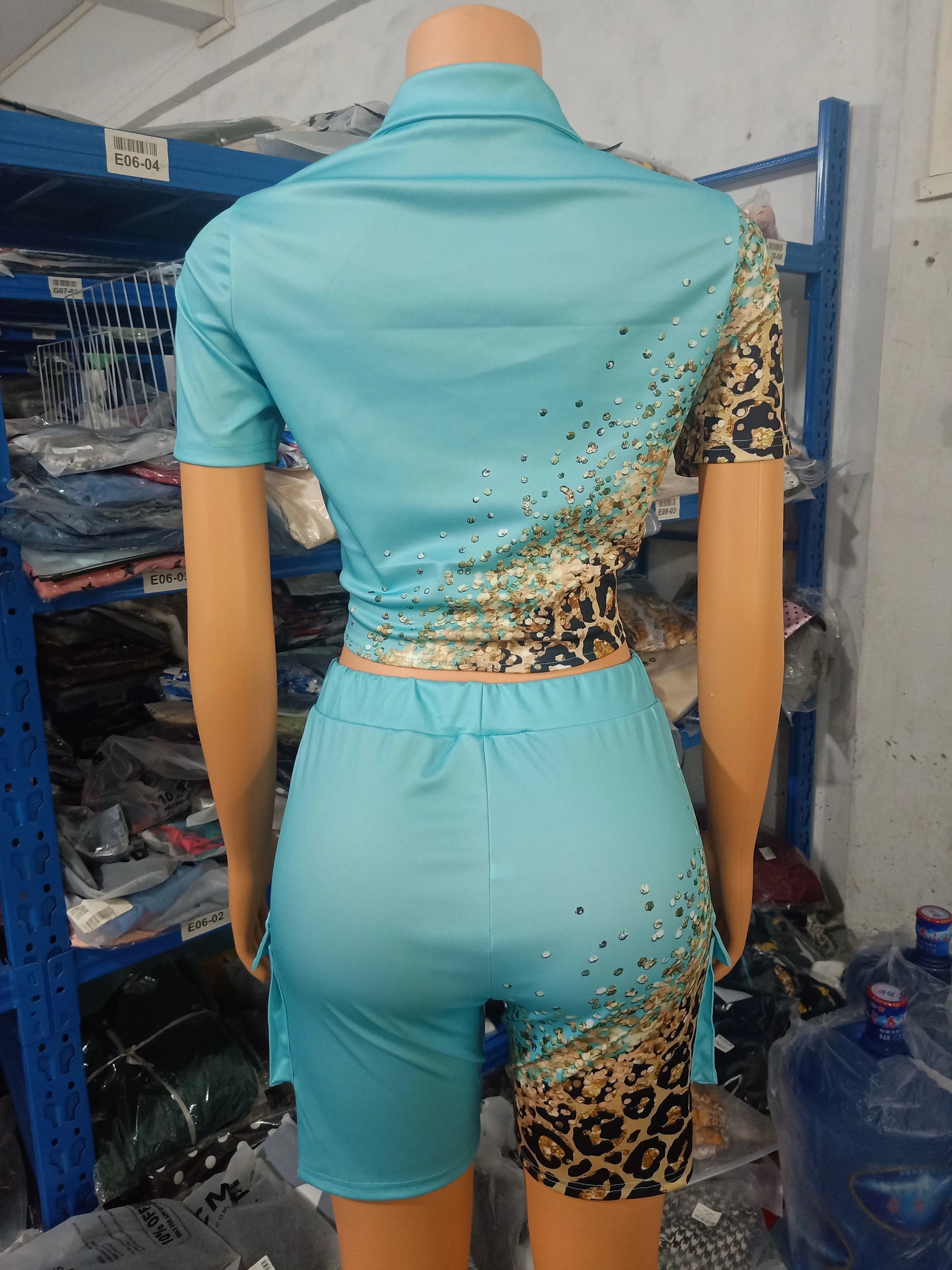Female mannequin wearing a two-piece summer set with leopard print and turquoise short-sleeve top and matching shorts