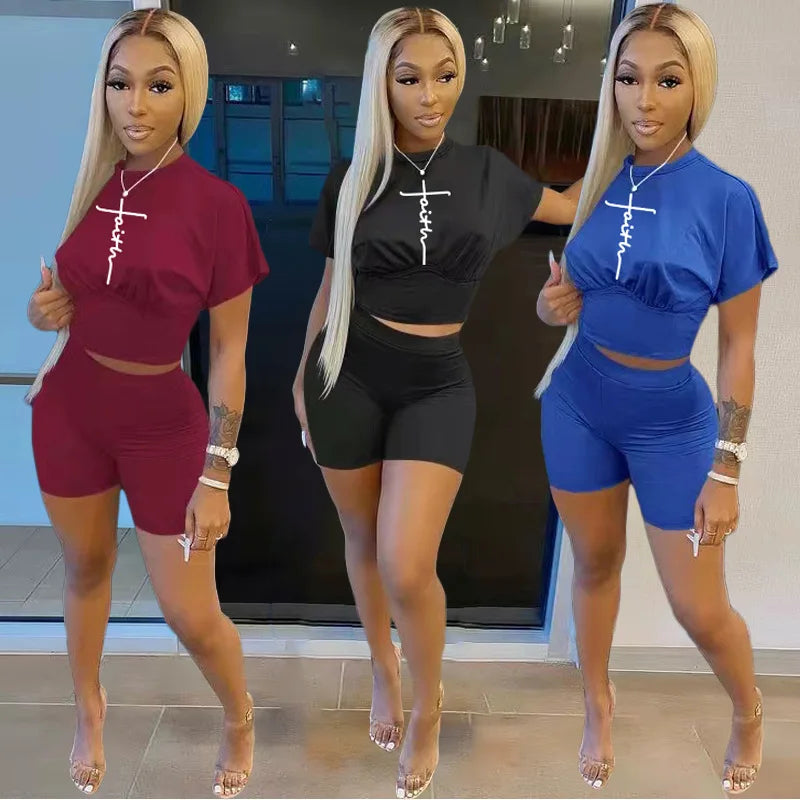 Three women wearing trendy two-piece summer shorts and t-shirt sets in red, black, and blue colors indoors