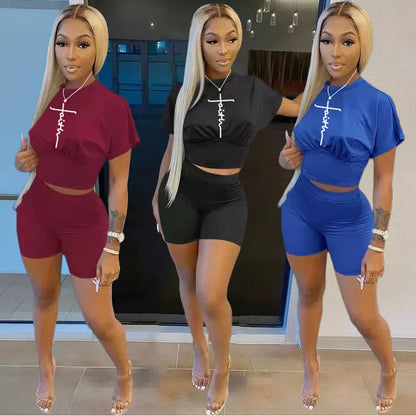 Three women wearing trendy two-piece summer shorts and t-shirt sets in red, black, and blue colors indoors