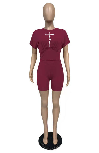 Female mannequin wearing a burgundy two-piece summer outfit with a short-sleeve top and fitted shorts
