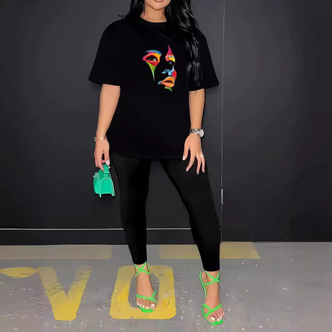 Woman wearing a black two-piece streetwear outfit with a colorful face print t-shirt and fitted elastic waist pants