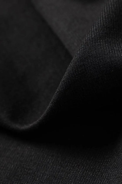 Close-up of black fabric texture showing fine knit detail and soft material of the t-shirt garment