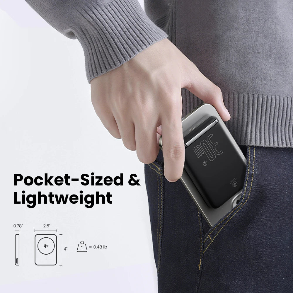 Hand holding a slim black 30W magnetic wireless power bank slipping into a front pants pocket
