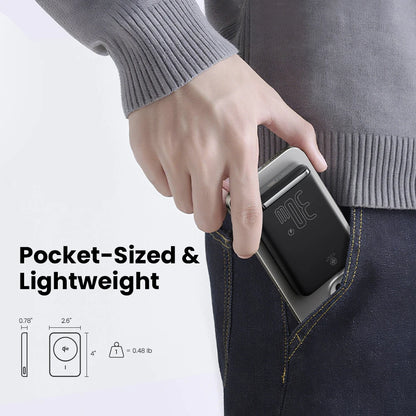 Hand holding a slim black 30W magnetic wireless power bank slipping into a front pants pocket