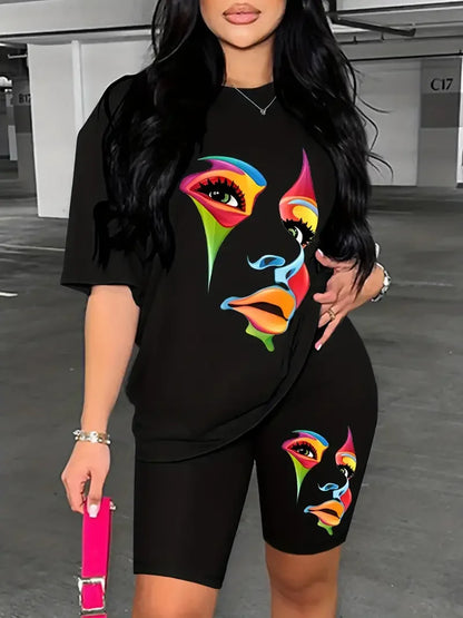 Woman wearing a black two-piece outfit with colorful abstract face print on oversized t-shirt and fitted shorts
