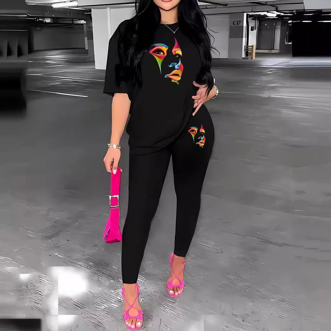 Woman wearing a black two-piece streetwear set with colorful face print on top and matching long elastic waist pants