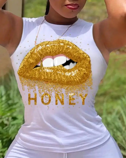 Woman wearing white sleeveless top with glittery gold lips and the word honey printed on front