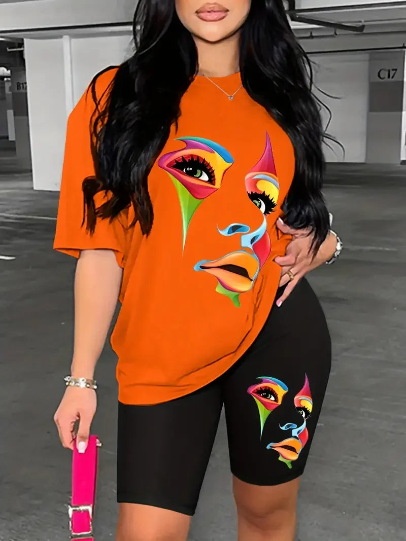 Woman wearing a two-piece outfit with an orange graphic t-shirt and black fitted shorts featuring a colorful face print