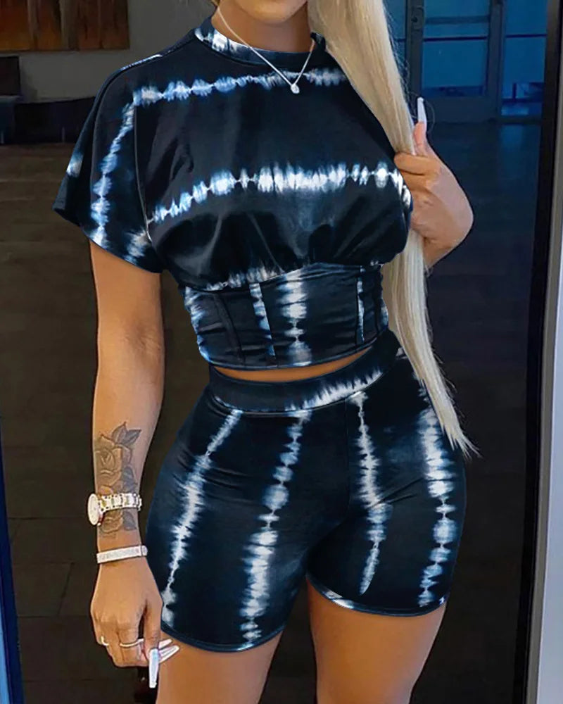 Woman wearing a black and white tie-dye two-piece outfit with a cropped t-shirt and shorts, summer casual style