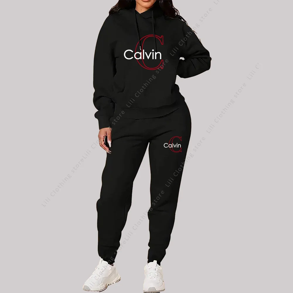 Woman wearing black designer two-piece tracksuit with hoodie and matching pants and white sneakers