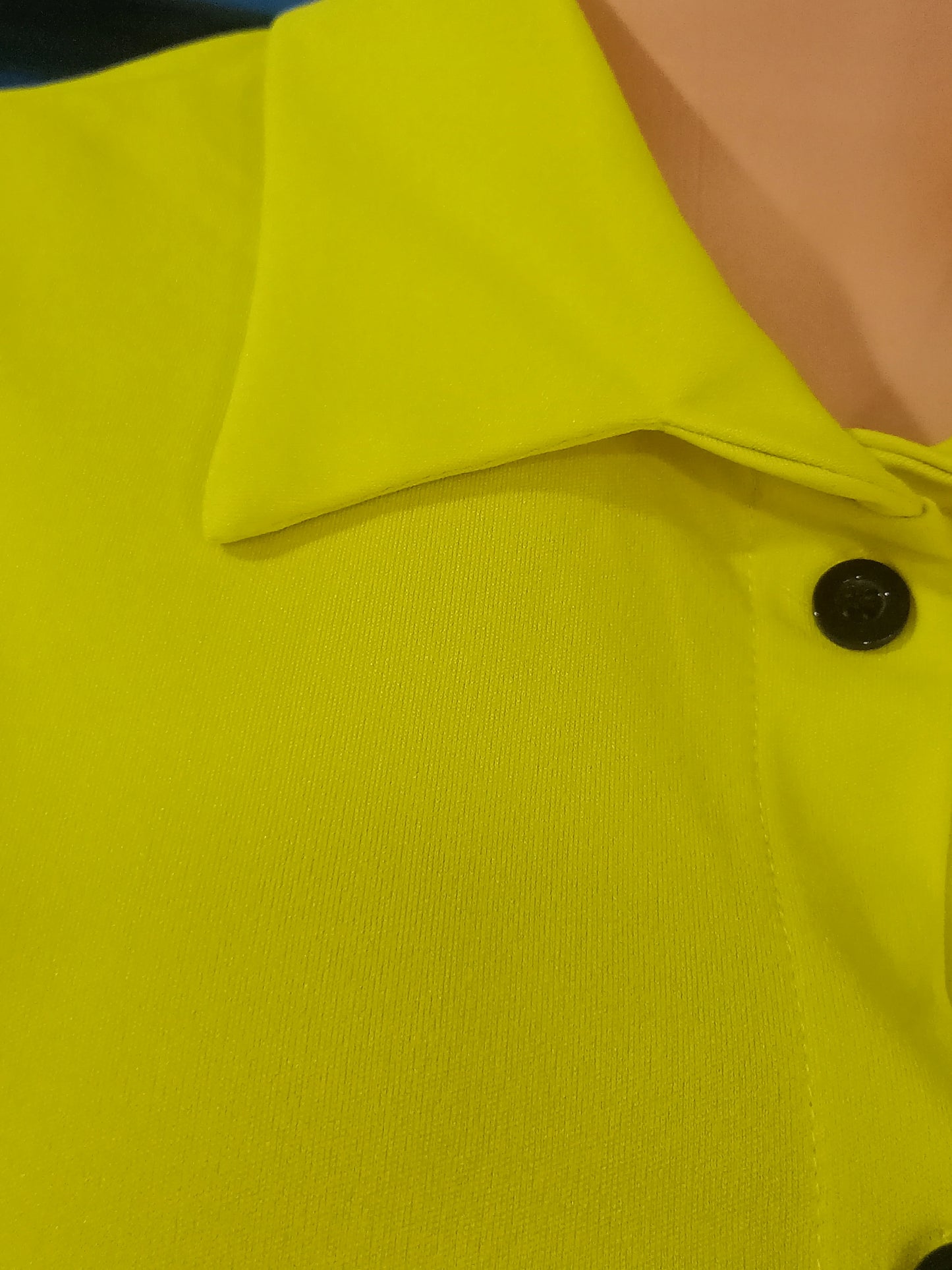 Close-up of a bright yellow collared short-sleeve top with button detail from a summer two-piece outfit