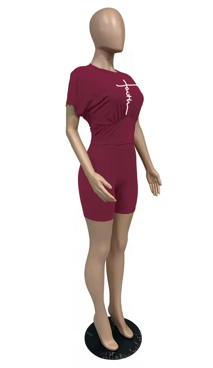 Female mannequin wearing a burgundy short-sleeve top and fitted biker shorts two-piece summer outfit