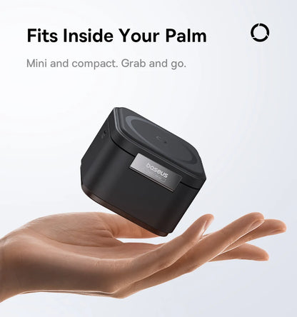 Compact black Baseus 3-in-1 magnetic wireless charger held above an open palm on a white background