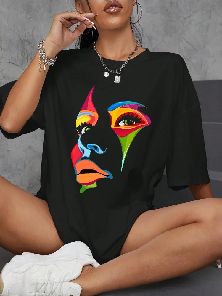 Woman wearing a black oversized t-shirt with colorful abstract painted face graphic in a streetwear style