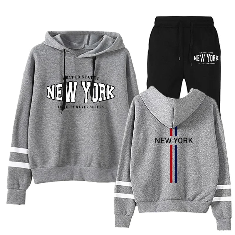 Woman's two-piece grey hoodie and black sweatpants jogging set with New York print and stripe details on sleeves and back hood