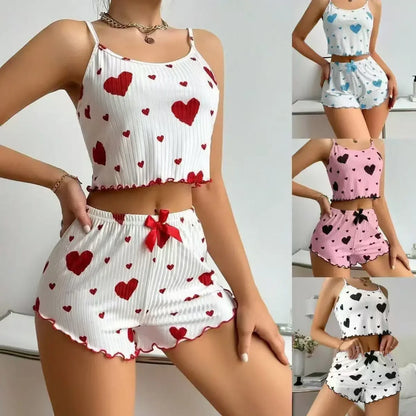 Woman wearing a two-piece heart print pajama set with cropped camisole and ruffled shorts in multiple colors