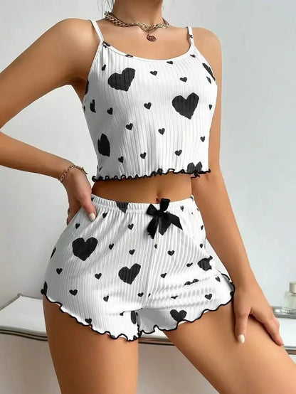 Woman wearing a white ribbed two-piece pajama set with black heart prints and black trim details