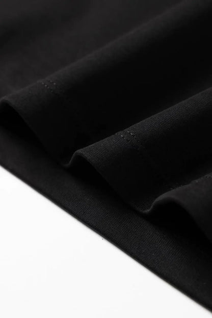 Close-up of black fabric hem detail on a Harajuku streetwear artistic t-shirt for women