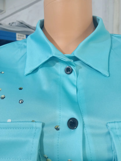 Close-up of light blue button-up summer top with collar and subtle printed details on mannequin