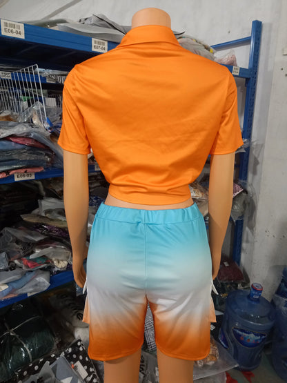 Female mannequin wearing a short-sleeve orange cropped top and ombre blue to orange shorts two-piece summer outfit