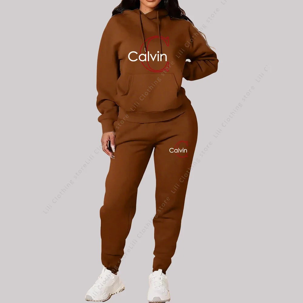 Brown two-piece women’s tracksuit with hoodie and joggers, featuring Calvin logo and white sneakers.