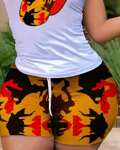 Close-up of woman wearing colorful tie-dye leopard print shorts with a white drawstring waistband and white tank top