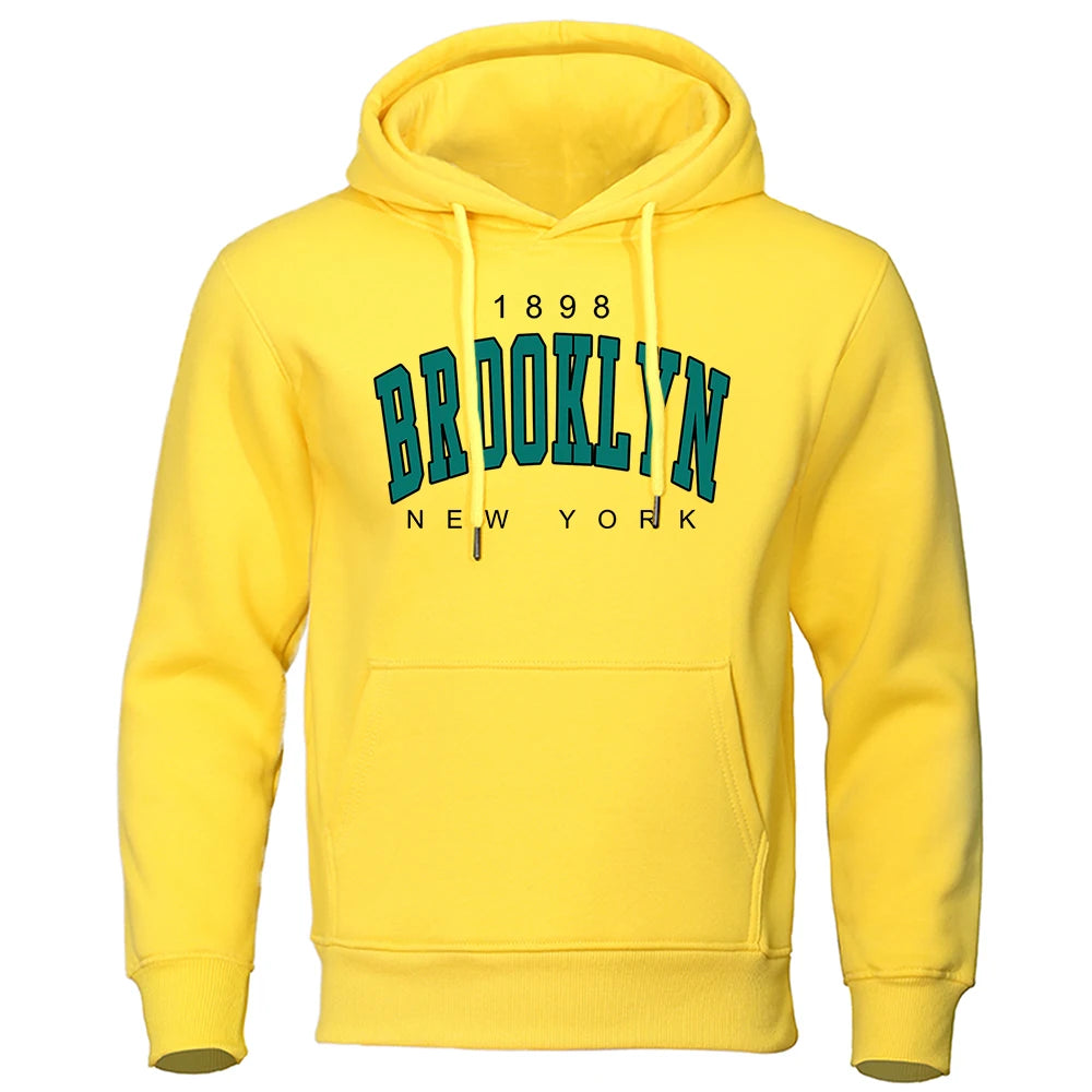 Yellow urban style hoodie for men with Brooklyn New York vintage print and front kangaroo pocket on white background