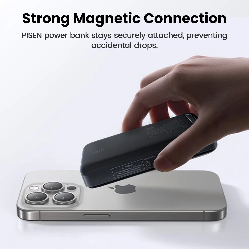 Hand holding a black PISEN magnetic power bank attaching it to the back of a silver iPhone with triple cameras