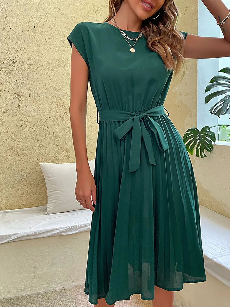 Elegant green pleated summer beach dress for women with belt, short sleeves, and casual fit on neutral background