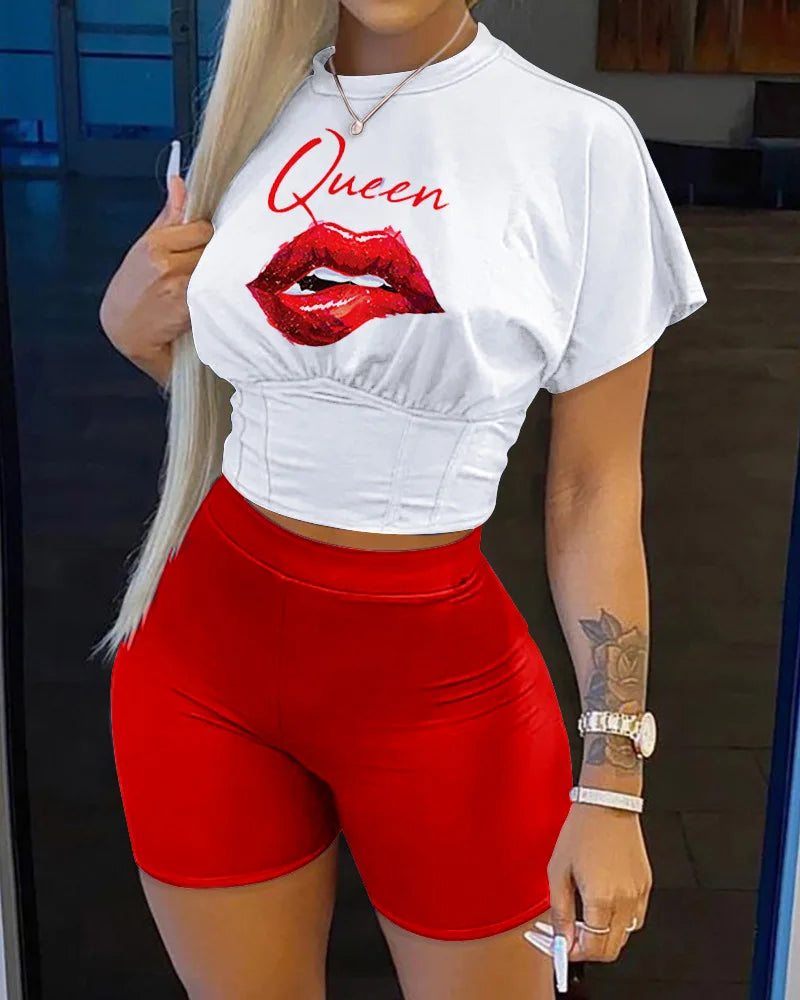 Woman wearing a two-piece summer outfit with a white cropped graphic t-shirt and fitted red biker shorts