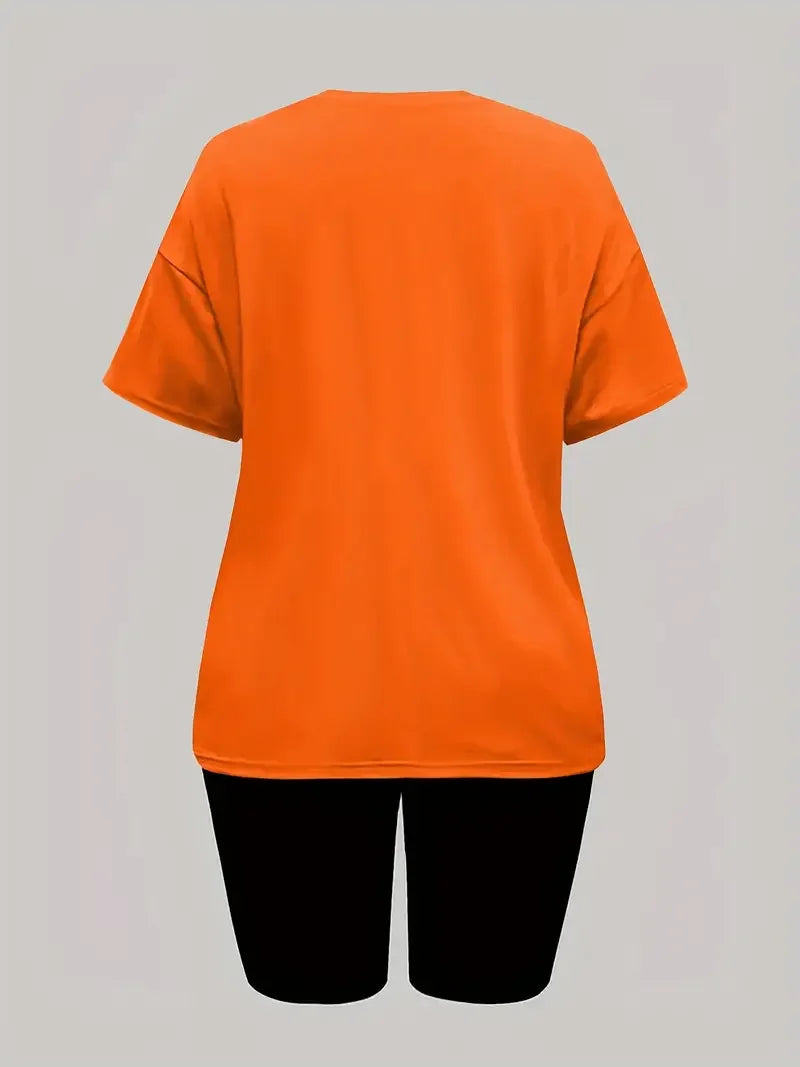 Woman wearing an orange short-sleeve t-shirt and black skinny shorts two-piece summer outfit shown from back