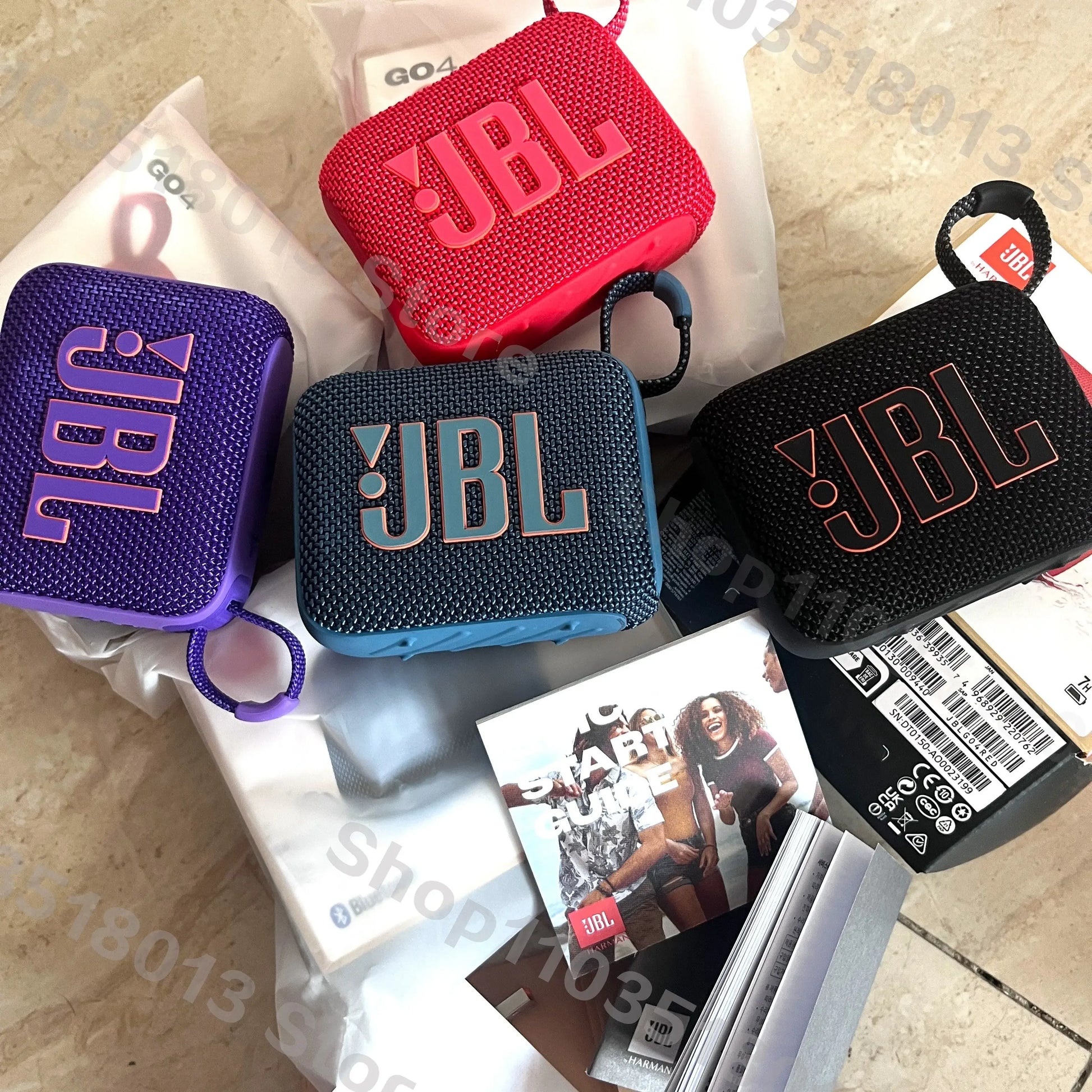 Four colorful JBL GO 4 portable Bluetooth speakers in purple, red, blue, and black on packaging and promotional materials.