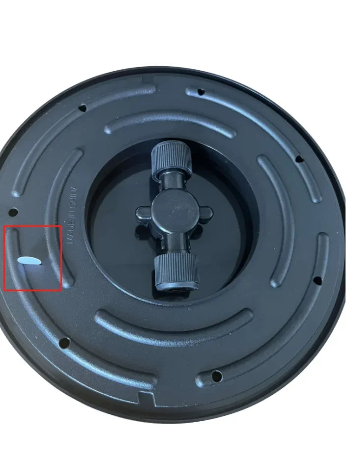 Close-up of black circular robot vacuum replacement part with adjustable knob and embossed text on surface