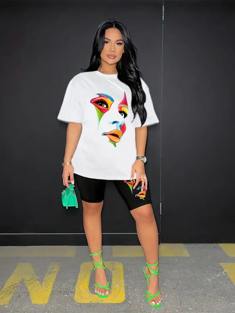 Woman wearing a two-piece outfit with a white graphic t-shirt and black skinny shorts featuring colorful face prints
