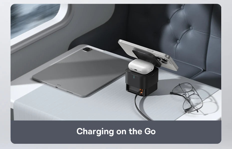 Baseus 3-in-1 magnetic wireless charger powering iPhone and AirPods on a travel tray table near a window